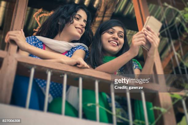 happy asian young women sharing mobile phone together. - human body part stock pictures, royalty-free photos & images