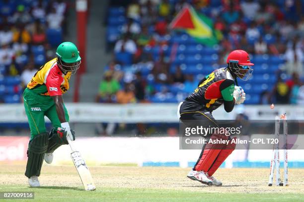 In this handout image provided by CPL T20, Devon Thomas of St Kitts and Nevis Patriots attempts to run out Jason Mohammed of the Guyana Amazon...