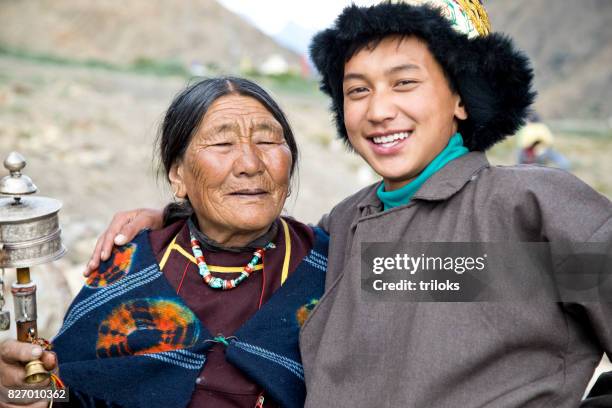 young boy with grandmother holding prayer wheel - prayer wheel stock pictures, royalty-free photos & images