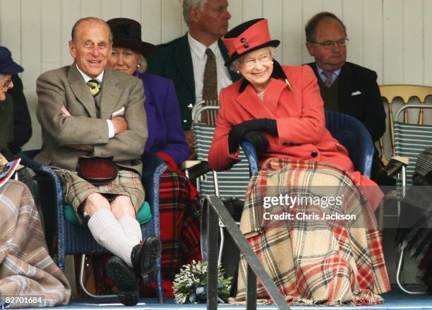 Queen Elizabeth II and Prince Philip, Duke of Edinburgh laugh as they watch the games during the Annual Braemar Highland Gathering on September 6,...