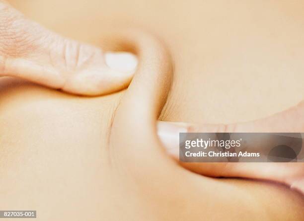 thumbs massaging small area of skin, close-up - massaggiare foto e immagini stock