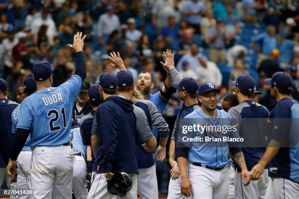 Steven Souza Jr. #20 of the Tampa Bay Rays, center, celebrates with teammates following his walk-off home run off of pitcher Jacob Barnes of the...