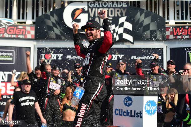 Martin Truex Jr., driver of the Furniture Row/Denver Mattress Toyota, celebrates in victory lane after winning the Monster Energy NASCAR Cup Series I...