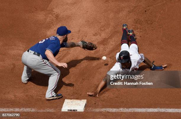 Byron Buxton of the Minnesota Twins dives back safely to first base as the ball gets past Mike Napoli of the Texas Rangers during the fourth inning...