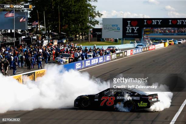 Martin Truex Jr., driver of the Furniture Row/Denver Mattress Toyota, celebrates with a burnout after winning the Monster Energy NASCAR Cup Series I...