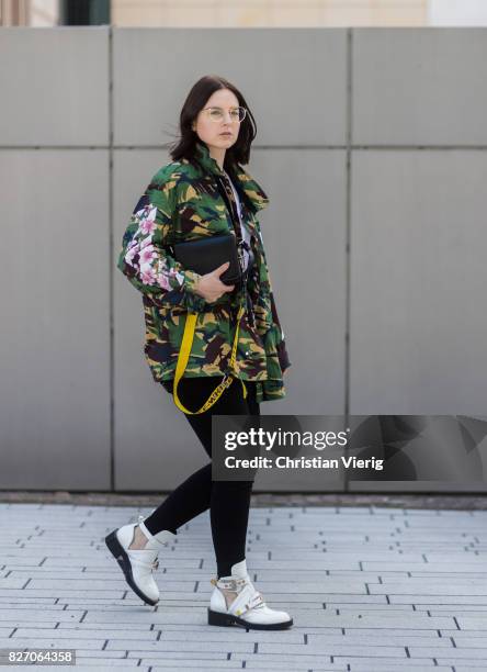 Fashion blogger and stylist Maria Barteczko wearing an Off White jacket with camouflage print, white Balenciaga tshirt, glasses, black Citizens of...