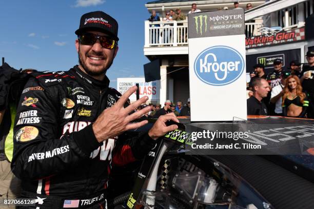 Martin Truex Jr., driver of the Furniture Row/Denver Mattress Toyota, celebrates his fourth win by adding the winner's sticker to his car in Victory...