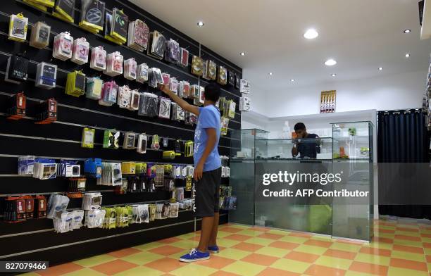 Libyan man shops at a store that accepts electronic payment systems via a mobile phone app, in the city of Benghazi, on July 24, 2017. When a cash...