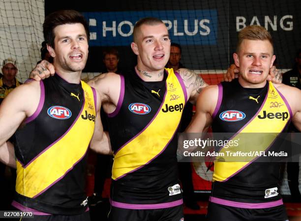 Trent Cotchin, Dustin Martin and Brandon Ellis of the Tigers sing the team song during the 2017 AFL round 20 match between the Richmond Tigers and...