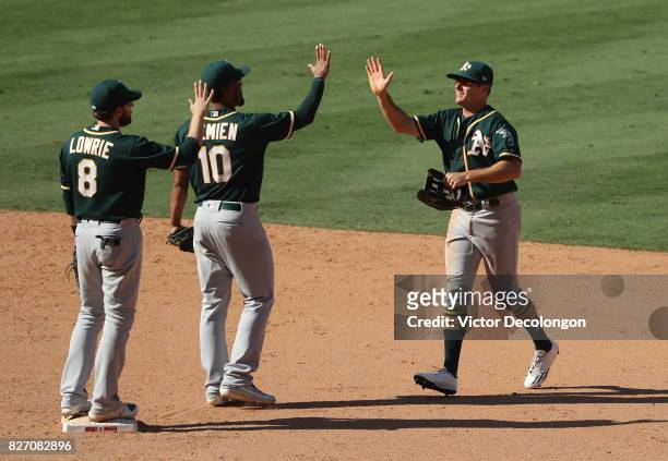 Jaycob Brugman of the Oakland Athletics, right, looks to give teammate Marcus Semien a high-five to celebrate their win in their MLB game against the...