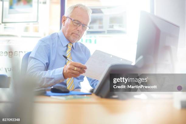 reading through the financial figures - only mature men stock pictures, royalty-free photos & images