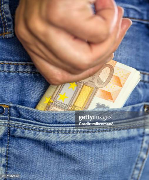 man putting a wad of cash into the pocket of his jeans - phone in back pocket stock pictures, royalty-free photos & images