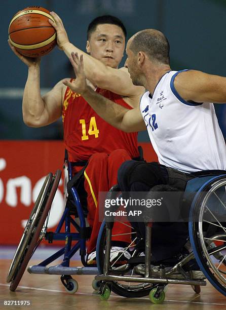 Chen Haijiang of China tries to shoot pass Liran Hendel of Israel during their 2008 Beijing Paralympic Games men's wheelchair basketball preliminary...