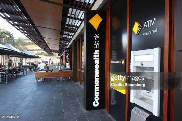 Signage for Commonwealth Bank of Australia is displayed next to an automated teller machine outside a branch in Sydney, Australia, on Monday, Aug. 7,...