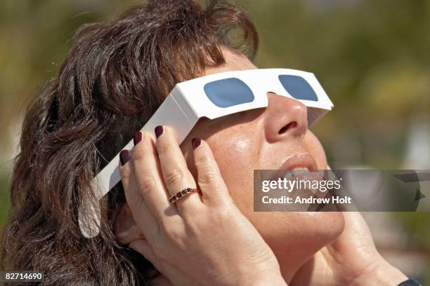 woman with solar glasses looking at sun - eclipse photos et images de collection