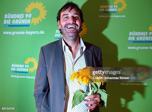 Sepp Daxenberger, top candidate of the Bavarian Green Party poses with a sunflower during the traditional Gillamoos 'Political Monday' on September...