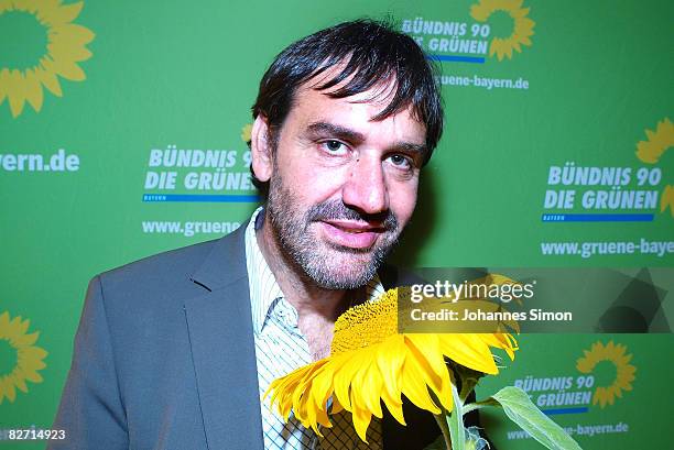 Sepp Daxenberger, top candidate of the Bavarian Green Party poses with a sunflower during the traditional Gillamoos 'Political Monday' on September...