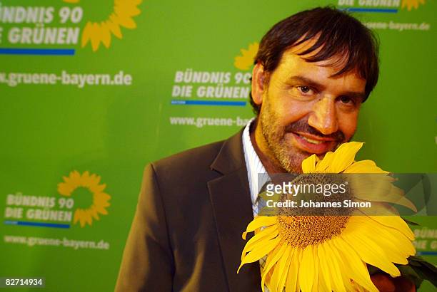 Sepp Daxenberger, top candidate of the Bavarian Green Party poses with a sunflower during the traditional Gillamoos 'Political Monday' on September...