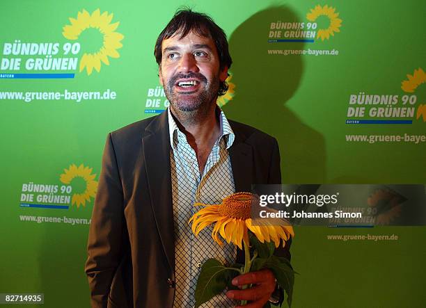 Sepp Daxenberger, top candidate of the Bavarian Green Party poses with a sunflower during the traditional Gillamoos 'Political Monday' on September...