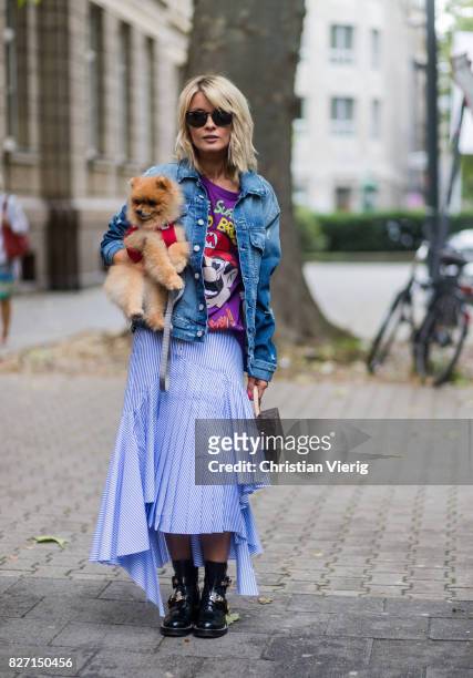 Model and fashion blogger Gitta Banko with a Pomeranian boo dog wearing a stripped pleated-skirt with a cut by Main Label, purple hand-painted...