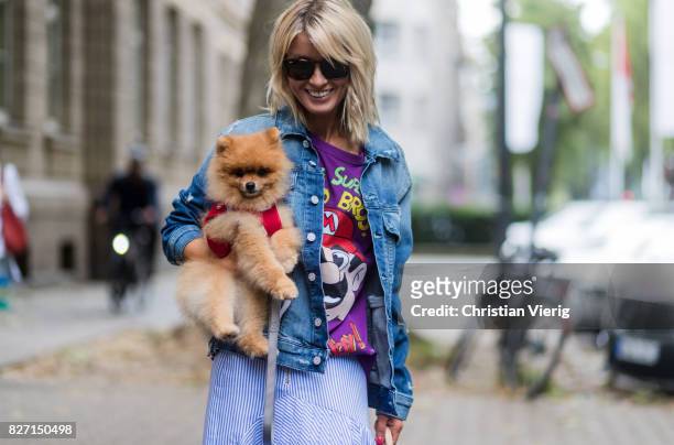 Model and fashion blogger Gitta Banko with a Pomeranian boo dog wearing a stripped pleated-skirt with a cut by Main Label, purple hand-painted...