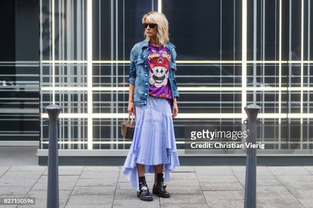 Model and fashion blogger Gitta Banko wearing a stripped pleated-skirt with a cut by Main Label, purple hand-painted t-shirt with Super Mario Bros....