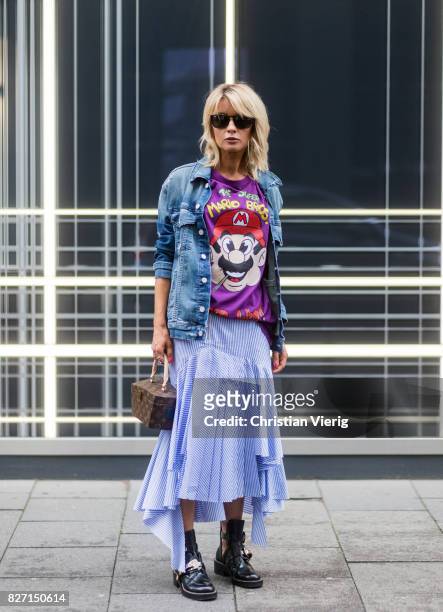Model and fashion blogger Gitta Banko wearing a stripped pleated-skirt with a cut by Main Label, purple hand-painted t-shirt with Super Mario Bros....