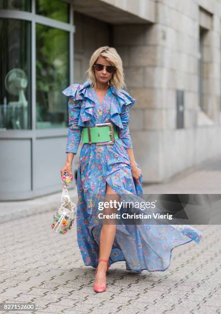 Model and fashion blogger Gitta Banko wearing a floral-patterned dress and a pastel-green oversize waist belt by Marina Hoermanseder, a Kasper...