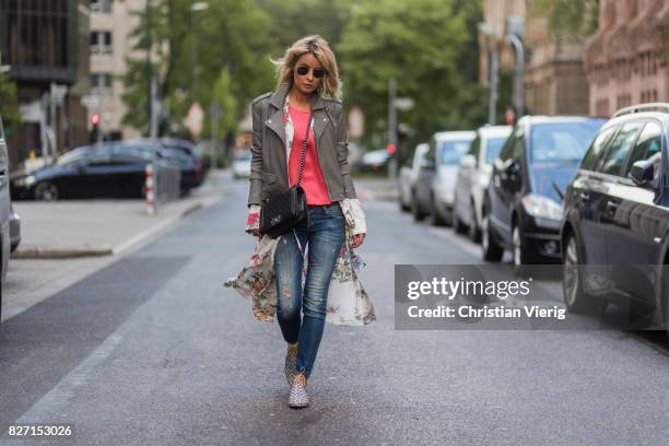 Model and fashion blogger Gitta Banko wearing a light grey biker leather jacket by Iro, a pink top by Marina Hoermanseder, floral-patterned silk...