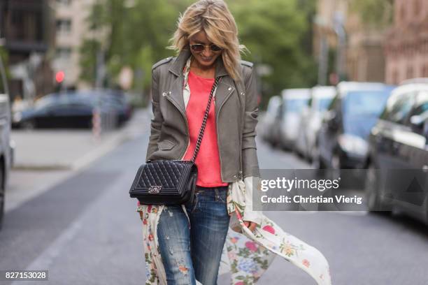 Model and fashion blogger Gitta Banko wearing a light grey biker leather jacket by Iro, a pink top by Marina Hoermanseder, floral-patterned silk...