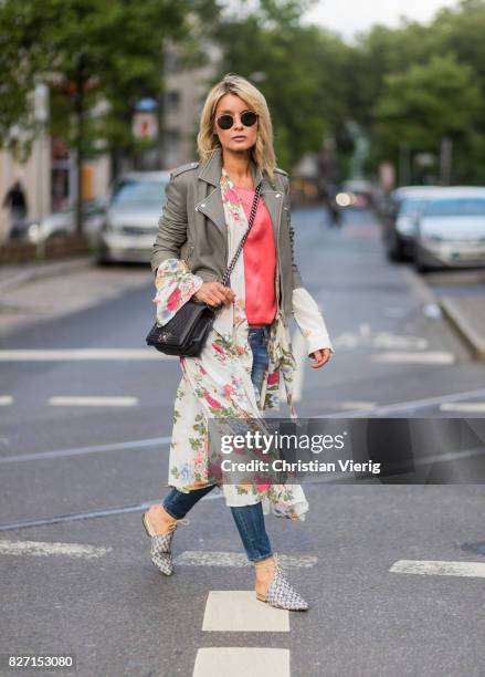 Model and fashion blogger Gitta Banko wearing a light grey biker leather jacket by Iro, a pink top by Marina Hoermanseder, floral-patterned silk...