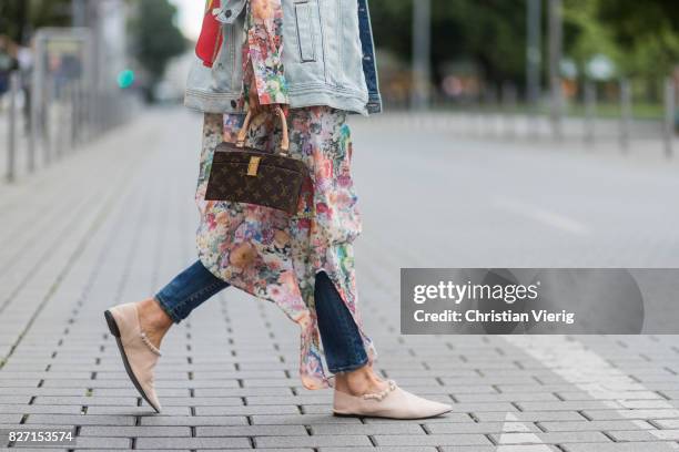 Model and fashion blogger Gitta Banko wearing a long cotton floral-patterned blouse by MM6 Maison Margiela, jeans jacket with hand-painted Matryoshka...