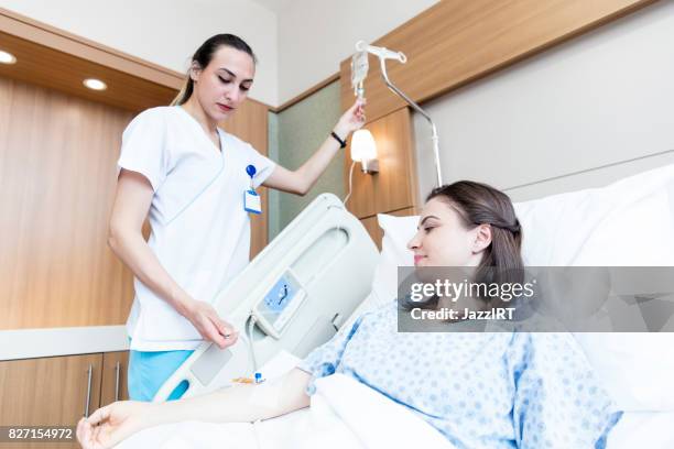 iv drip being inserted into a patient's hand - inserting iv stock pictures, royalty-free photos & images