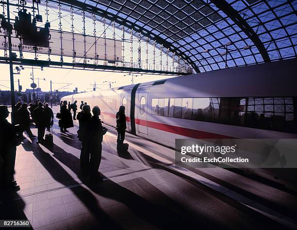 silhouettes of commuters waiting for train - ice-zug stock-fotos und bilder