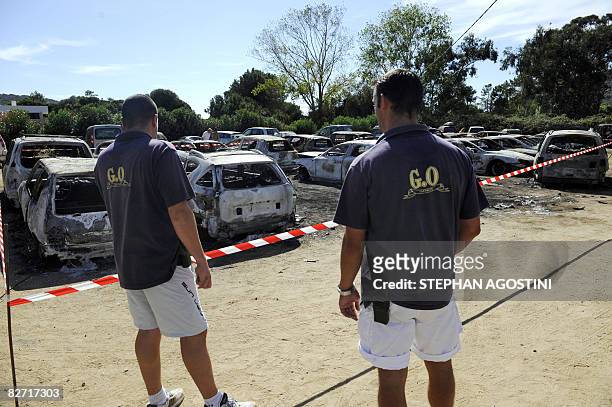 "Club Mediterranee" holiday resort staff look on September 8, 2008 in Cargese on the French Corsica island at burnt vehicules carcasses on the...