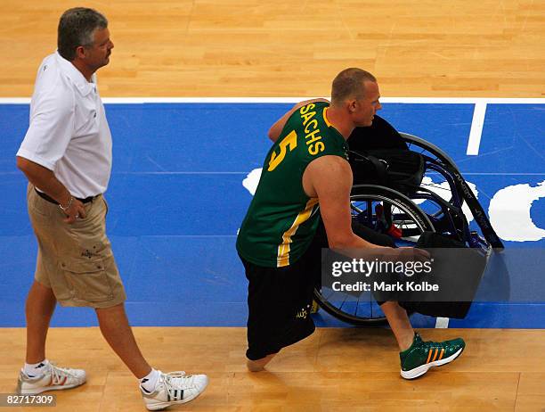 Troy Sachs of Australia walks to the bench carrying the seat from his chair during the Wheelchair Basketball match between Australia and Great...