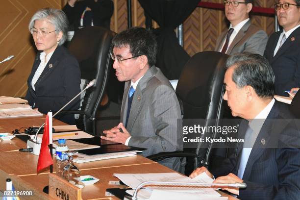 Japanese Foreign Minister Taro Kono speaks while seated next to South Korean Foreign Minister Kang Kyung Wha and Chinese Foreign Minister Wang Yi, at...