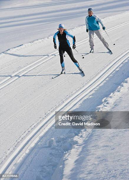 two women cross-country skiing. - womens us ski team stock pictures, royalty-free photos & images