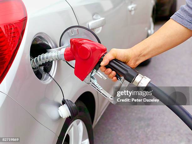 woman filling car with leaded fuel. - petrol stock-fotos und bilder