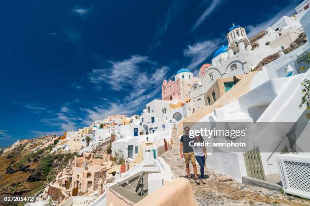 young couple walking in oia santorini - couple europe stock pictures, royalty-free photos & images