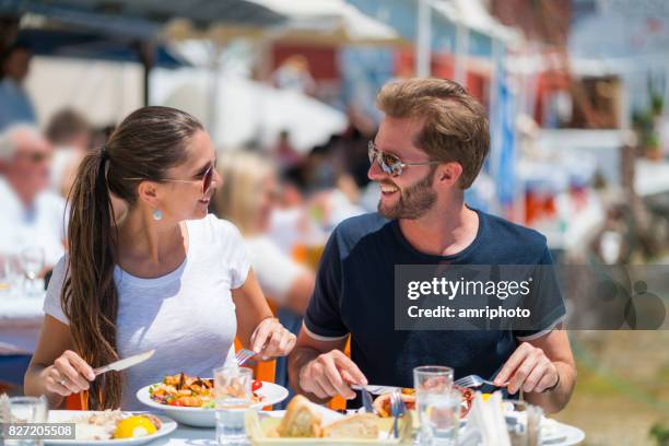 young couple enjoying healthy lunch together in greece - greek food stock pictures, royalty-free photos & images