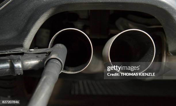 Hose for an emission test is fixed in the exhaust pipe of a Volkswagen Golf 2,0 litre diesel car at the Technical Inspection Agency in Ludwigsburg,...