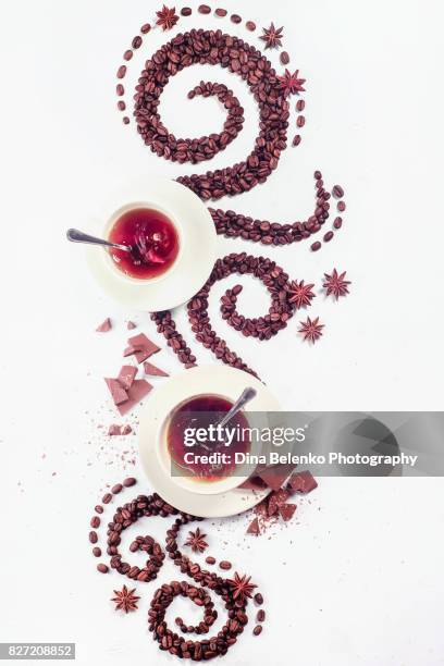 coffee grains lying in the shape of a swirl with the cup, cinnamon, anise stars and chocolate - chocolate swirl from above stock pictures, royalty-free photos & images