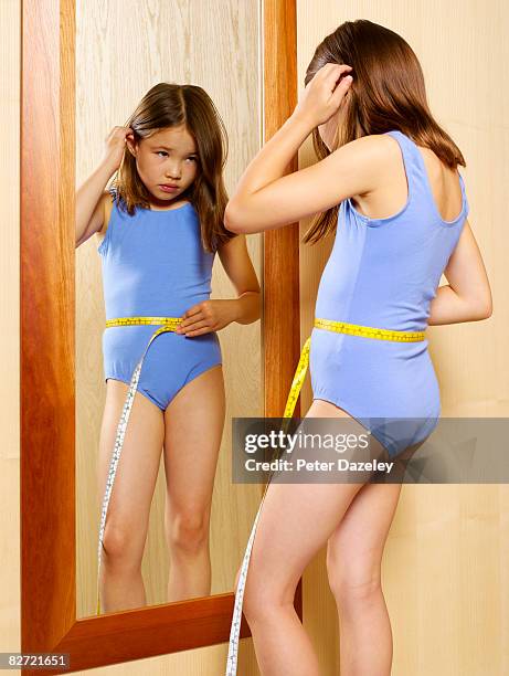 child measuring herself in mirror - body dysmorphia stock pictures, royalty-free photos & images