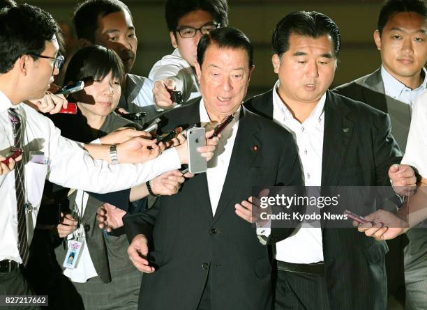 Tetsuma Esaki , the new minister in charge of issues related to Okinawa, is surrounded by reporters at the prime minister's office in Tokyo on Aug. 7...