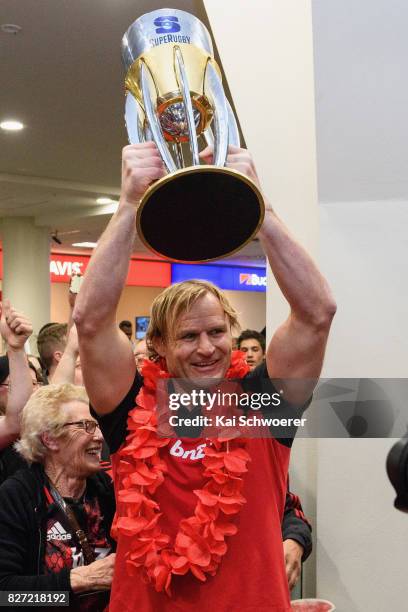 Head Coach Scott Robertson of the Crusaders lifts the Super Rugby trophy during the Crusaders arrival at Christchurch Airport on August 7, 2017 in...