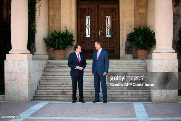 Spain's King Felipe VI and Spanish Prime Minister Mariano Rajoy pose before their meeting at the Marivent Palace in Palma de Mallorca on August 7,...