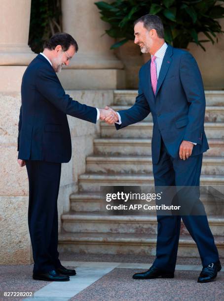 Spain's King Felipe VI shakes hands with Spanish Prime Minister Mariano Rajoy before their meeting at the Marivent Palace in Palma de Mallorca on...