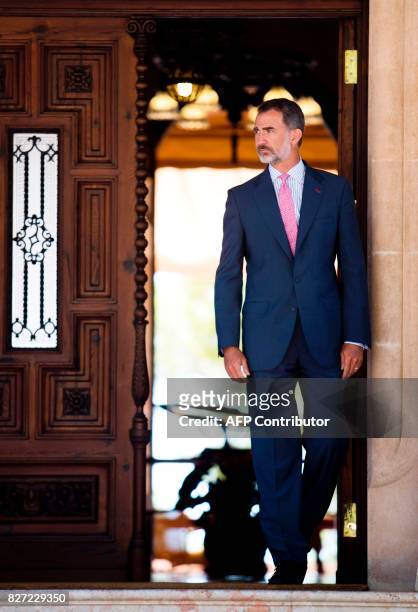 Spain's King Felipe VI waits for Spanish Prime Minister Mariano Rajoy before their meeting at the Marivent Palace in Palma de Mallorca on August 7,...
