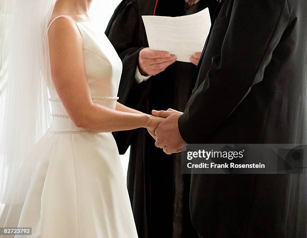 bride and groom exchange vows holding hands - married church stock pictures, royalty-free photos & images